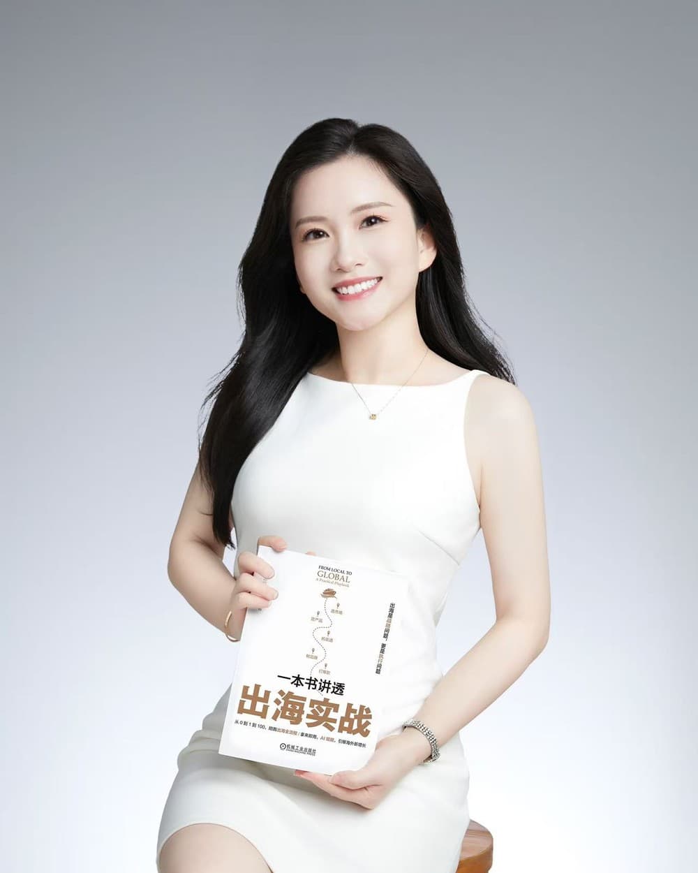 Annie Chan holding her book 一本书讲透出海实战 (From Local to Global)